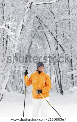 Young woman in snow holding ski sticks