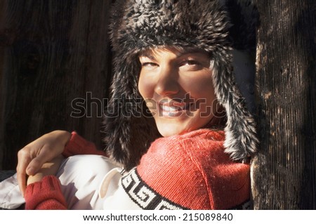 Woman leaning against wooden wall, portrait