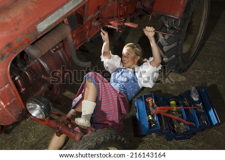 Young woman repairing tractor, portrait
