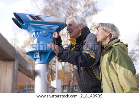 Senior couple, man looking through telescope