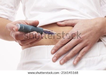 Young woman is injecting Insulin with a Insulin Pen