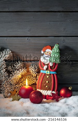 Gingerbread Santa Claus on pile of snow against wooden wall