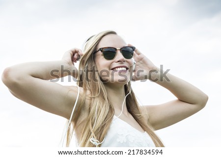 Young woman with headphones listening to music, low angle view