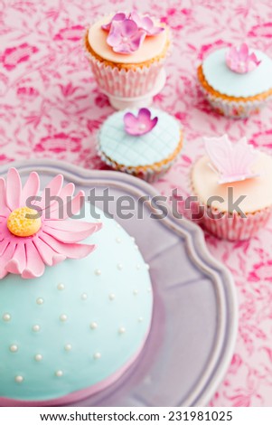 Round cake and cupcakes decorated with fondant and gum paste flowers