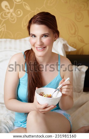 Woman in bed eating a healthy breakfast