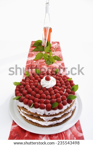 Raspberry cream cake on table runner and raspberry wine