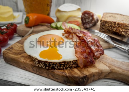 Hearty supper, fried egg and bacon on protein bread