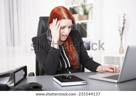 Stressed young businesswoman on laptop