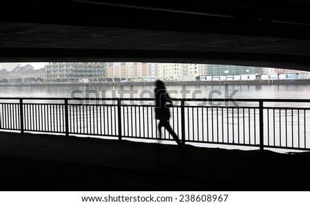 Germany, Berlin, Silhouette of running woman at river, fear, escape