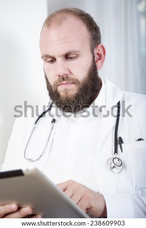 Doctor using digital tablet in practice