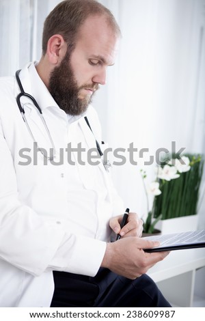 Doctor reading and signing report