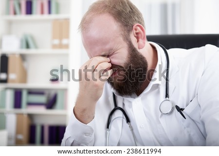 Over worked doctor sitting at desk