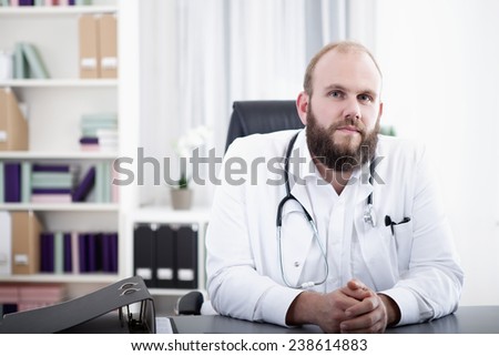 Doctor in practice sitting at desk