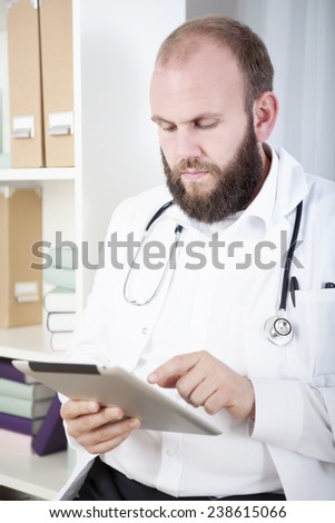 Doctor using digital tablet in practice
