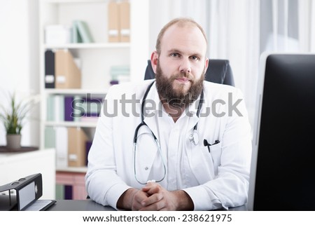 Doctor in practice sitting at desk