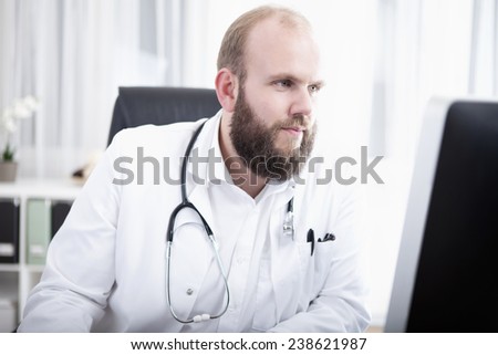 Doctor in practice working at computer