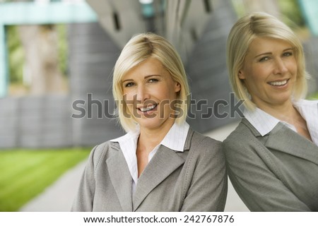 Germany, businesswoman smiling, mirror reflection