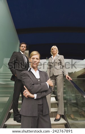 Germany, business people standing on stairs, portrait