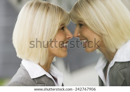 Germany, businesswoman looking at mirror image