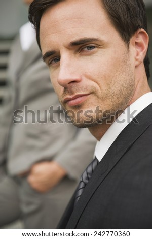 Germany, portrait of businessman, person in background