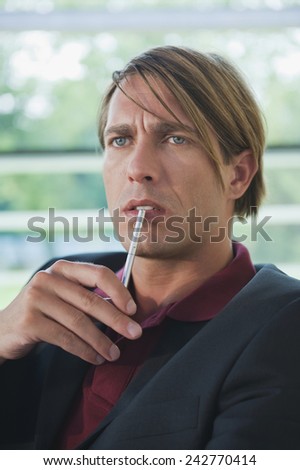 Germany, businessman holding pencil, portrait