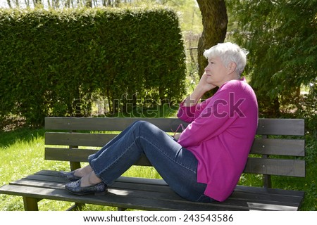 Senior woman sitting on bench, thoughtful