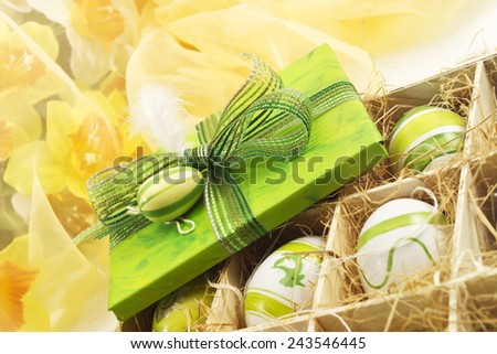 Green easter present with ribbon and easter egg, easter eggs in a box