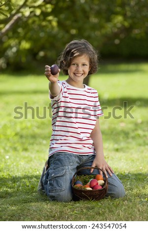 Germany, Girl with Easter eggs in basket, holding an egg portrait