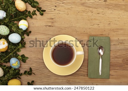 Easter decoration, coffee cup, napkin and spoon on wood