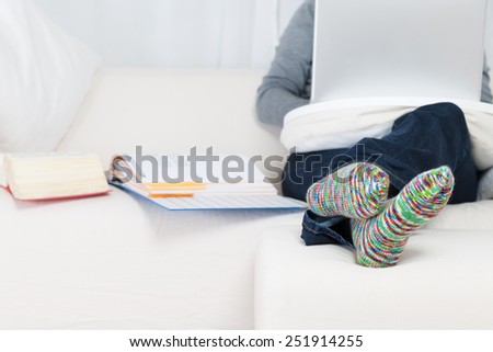 Young woman sitting with laptop on couch