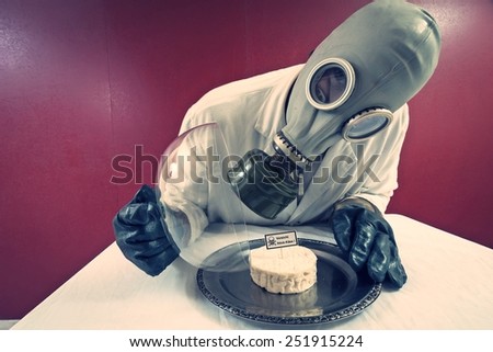 Man in front of a plate with cheese under cheese cover labelled 