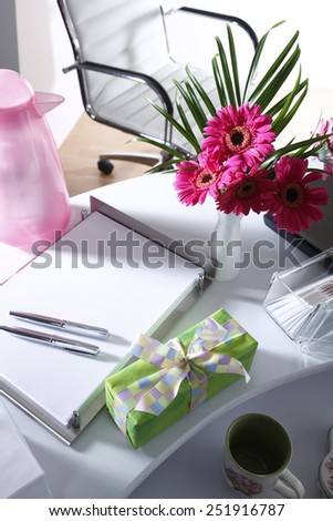 Present and flower vase on office table