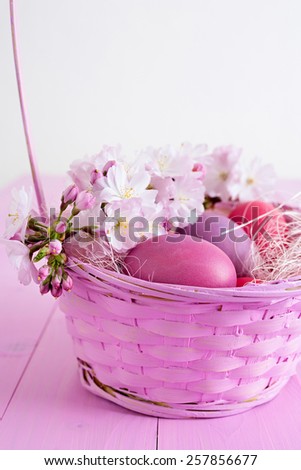 Pink Easter eggs in a pink basket with flowers