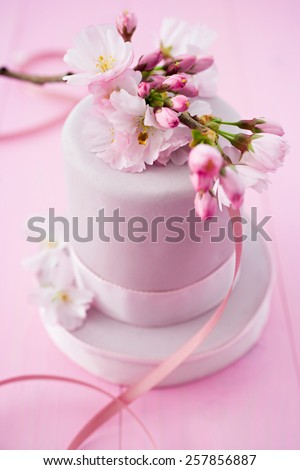 Pink cake decorated with fondant and cherryblossoms
