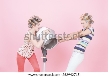 Young woman with curlers, quarreling about hood drier