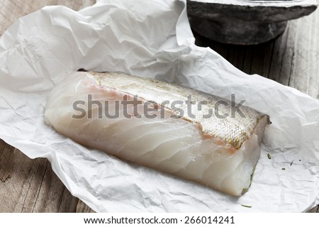 Row fish fillet, cod on greaseproof paper