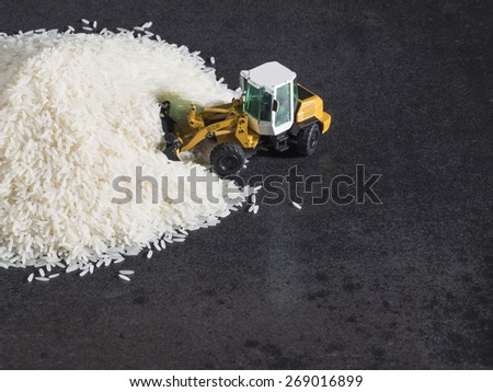 Toy digger on pile of rice, staple, distribution, trade