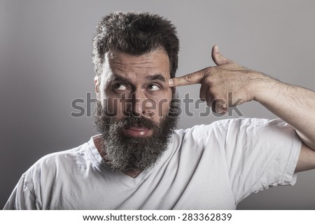 Portrait, man with full-beard, finger like a weapon on head