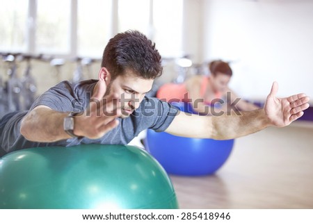 Couple training in fitness studio on gym balls