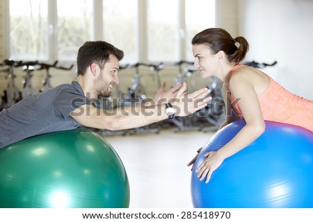 Couple training in fitness studio on gym balls