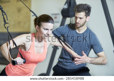 Couple in fitness studio at suspension training