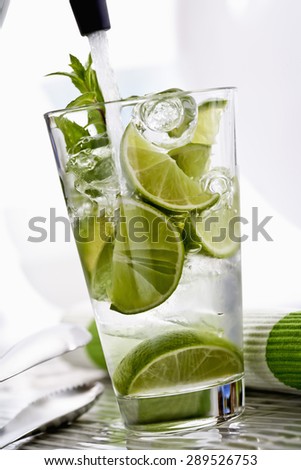 Caipirinha with ice, lime in a glass, splash of soda