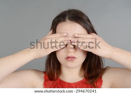 Young woman making hand gestures, see no evil