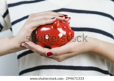 Woman holding red piggy bank