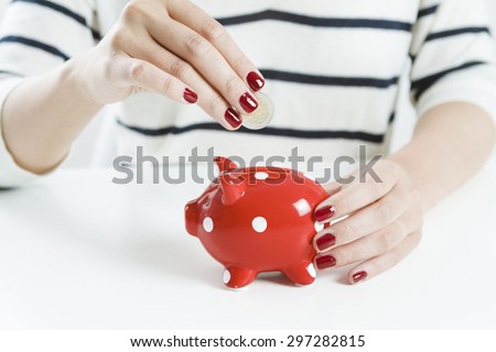 Woman saving money with red piggy bank