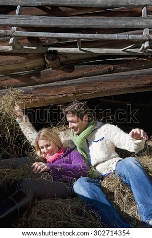 Austria,Salzburg Country,Flachau,Man and women lying in hay trailer