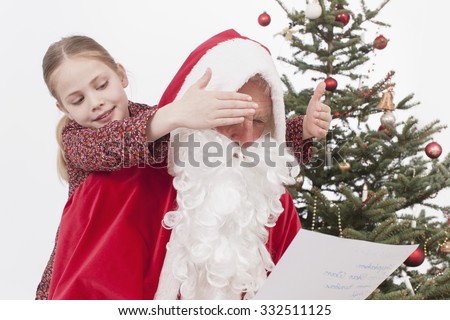 Girl covering eyes of Santa Claus