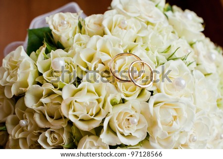 stock photo Wedding rings are on the wedding bouquet of flowers