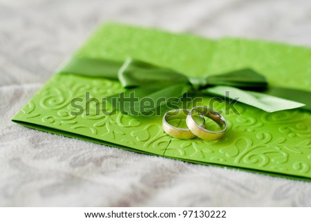 Wedding rings are on the green invitation to the feast
