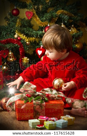 baby play with present box at Christmas tree